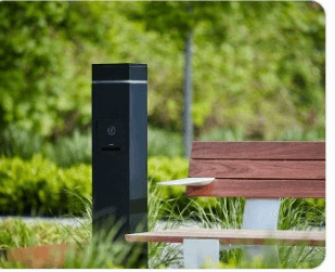Protected outdoor charging station beside a garden bench